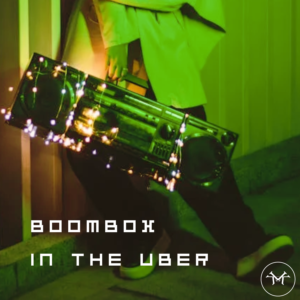 Person stands holding an old-fashioned boombox. Title reads boombox in the Uber with a Koshiz Music logo in the corner of the picture